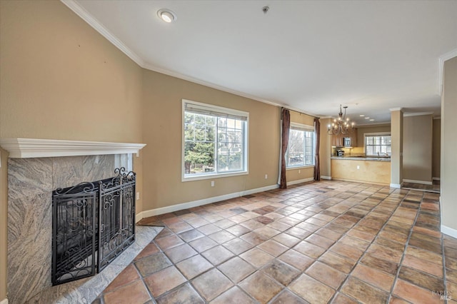 unfurnished living room with a tile fireplace, a chandelier, tile patterned floors, and crown molding