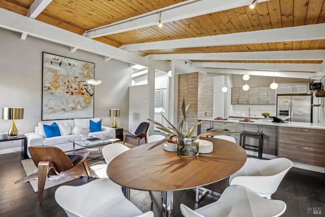 dining space with dark wood-style floors, lofted ceiling with beams, track lighting, wooden ceiling, and baseboards