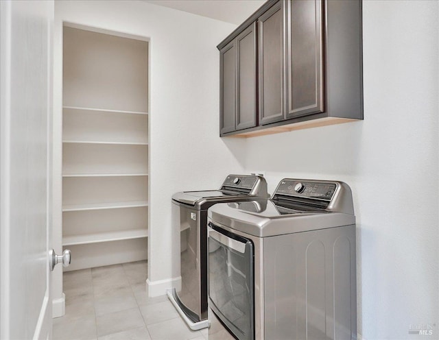 laundry area featuring cabinets, separate washer and dryer, and light tile patterned floors