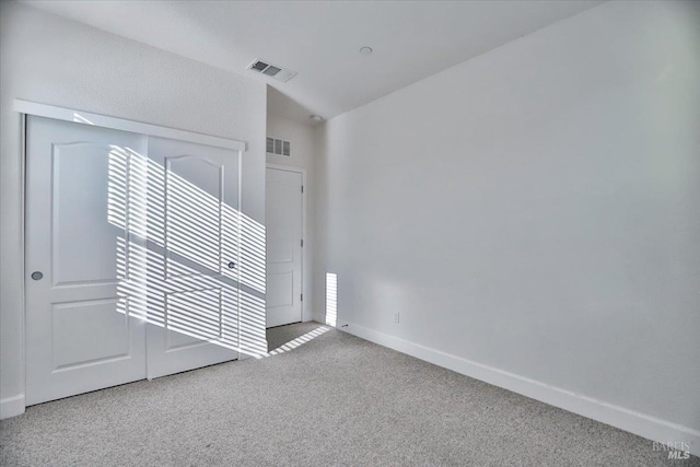 empty room featuring lofted ceiling and carpet floors