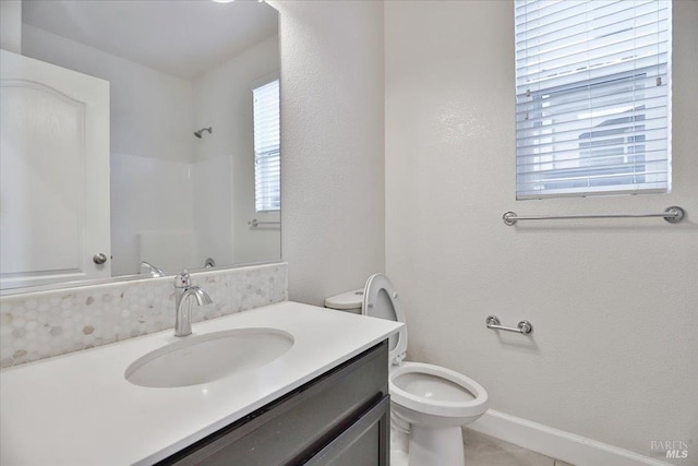 bathroom with vanity, a shower, and toilet