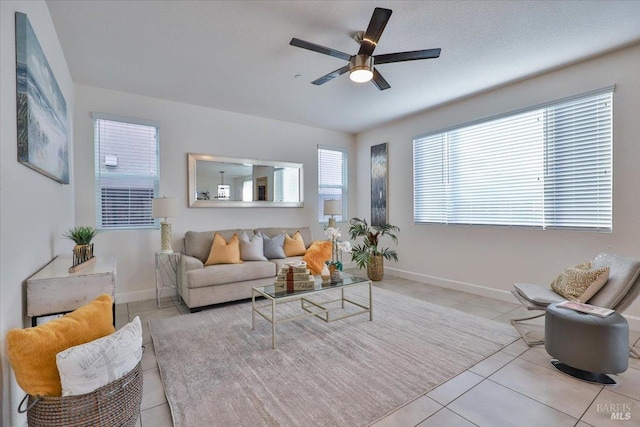 living room featuring light tile patterned floors, a textured ceiling, and ceiling fan