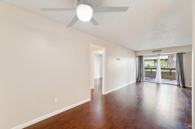 spare room featuring dark hardwood / wood-style flooring, ceiling fan, and a textured ceiling