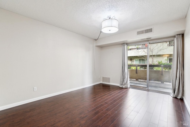 unfurnished room featuring dark hardwood / wood-style flooring and a textured ceiling