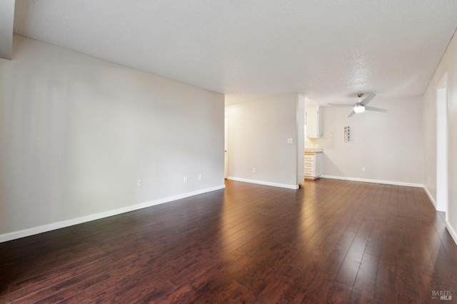 unfurnished room with ceiling fan, dark hardwood / wood-style floors, and a textured ceiling