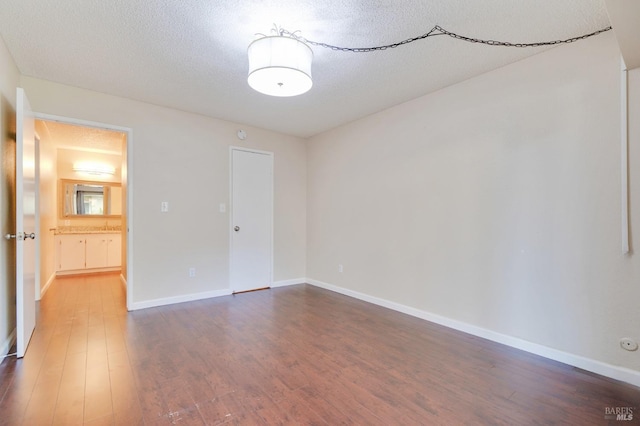 spare room featuring wood-type flooring and a textured ceiling