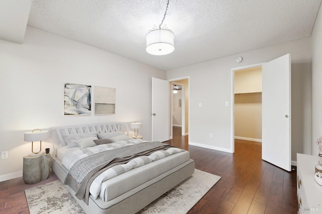 bedroom featuring dark hardwood / wood-style flooring and a textured ceiling