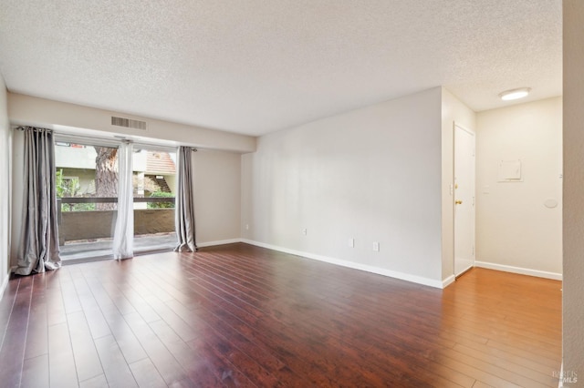 spare room with dark wood-type flooring and a textured ceiling