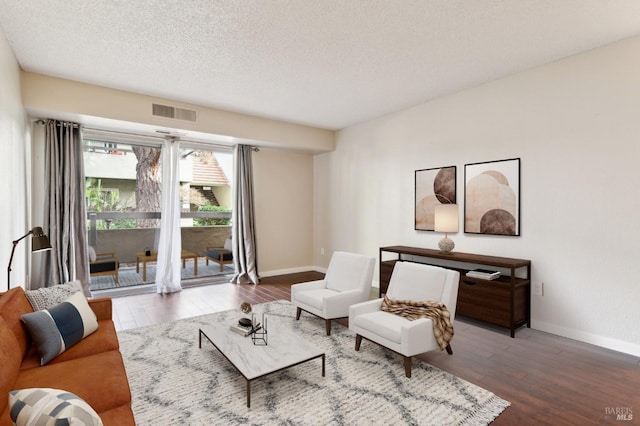 living area with hardwood / wood-style flooring and a textured ceiling