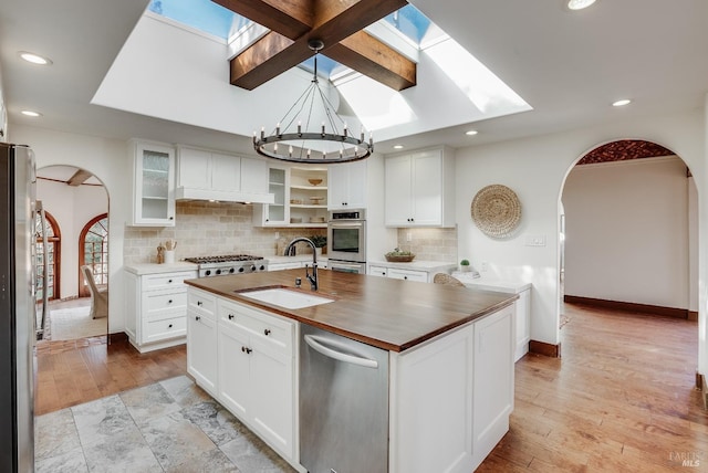 107 Deer Hollow Rd, San Anselmo, CA 94960 - kitchen with arched walkways, a sink, butcher block counters, a skylight, and recessed lighting