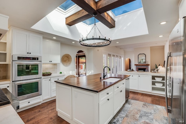 107 Deer Hollow Rd, San Anselmo, CA 94960 - kitchen featuring a sink, appliances with stainless steel finishes, a skylight, a chandelier, and a kitchen island with sink