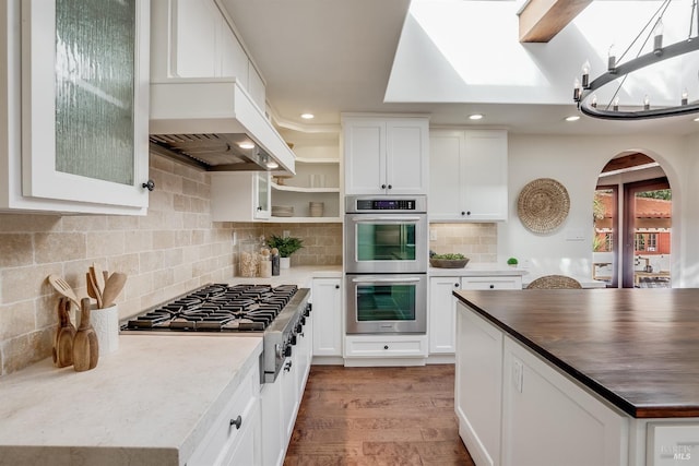 107 Deer Hollow Rd, San Anselmo, CA 94960 - kitchen with premium range hood, stainless steel appliances, arched walkways, light wood-style flooring, and open shelves