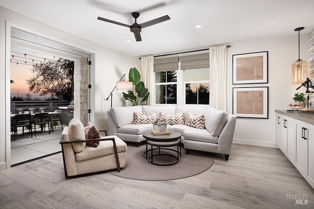 living room with ceiling fan and light wood-type flooring
