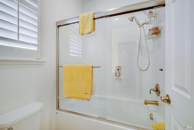 bathroom with enclosed tub / shower combo and toilet