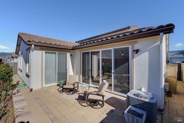 rear view of property featuring central AC and a patio area