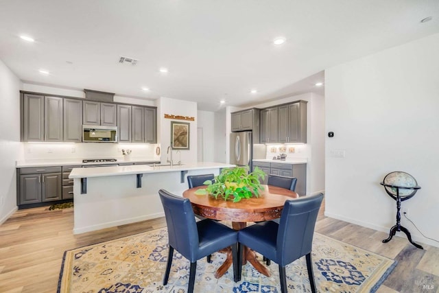 dining room with sink and light wood-type flooring