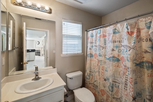 bathroom featuring vanity, toilet, and walk in shower