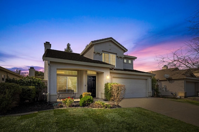 front of property featuring a garage, a lawn, and covered porch