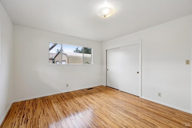 unfurnished bedroom with a closet and light wood-type flooring