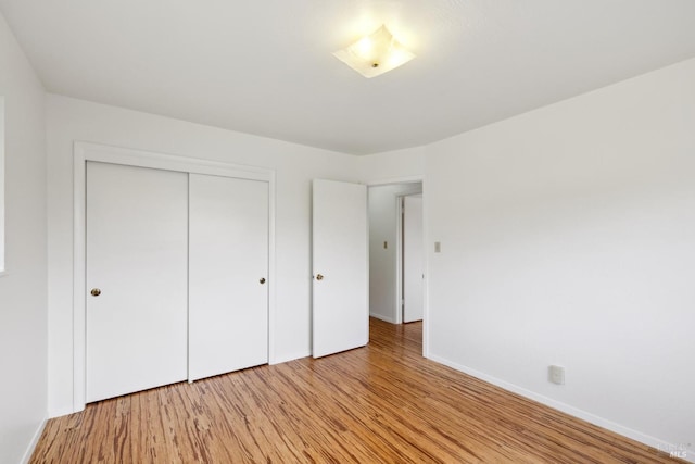 unfurnished bedroom with a closet and light hardwood / wood-style flooring