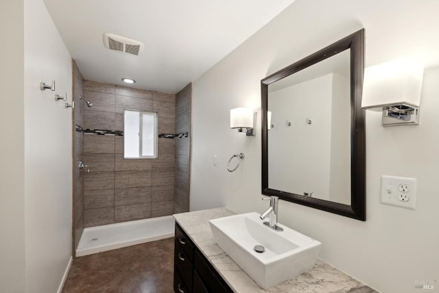 bathroom featuring vanity and tiled shower