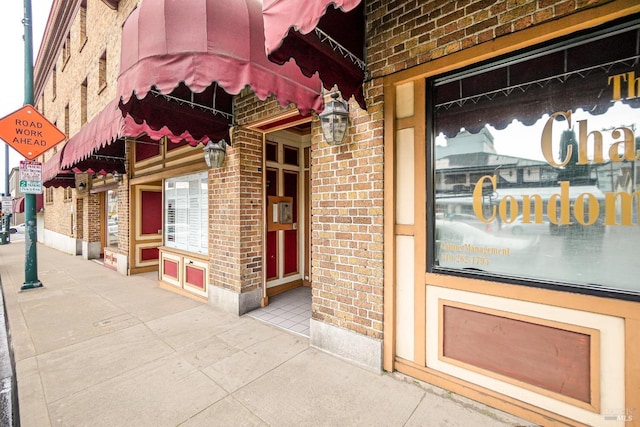 doorway to property featuring brick siding