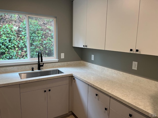 kitchen with white cabinetry and sink