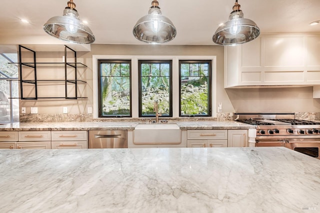 kitchen featuring sink, stainless steel appliances, white cabinets, and light stone counters