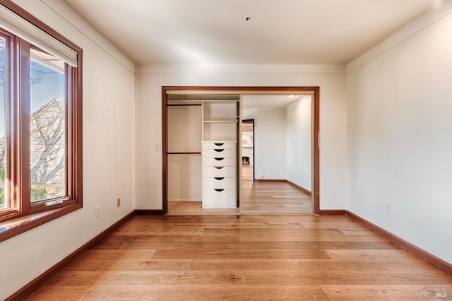 unfurnished bedroom featuring light wood-type flooring and a closet