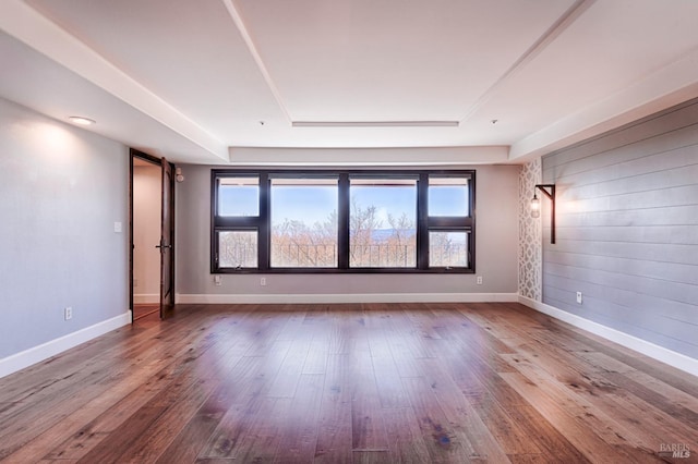 unfurnished room with a tray ceiling and hardwood / wood-style floors