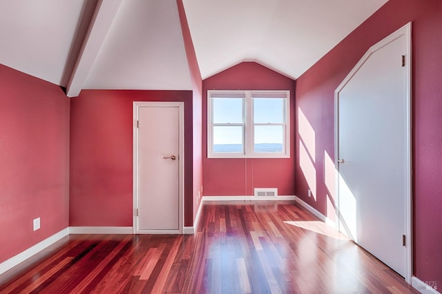 bonus room with hardwood / wood-style flooring and vaulted ceiling with beams