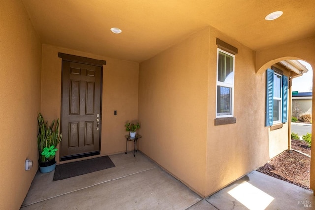 doorway to property featuring stucco siding