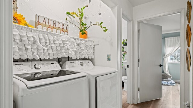 laundry area with laundry area, wood finished floors, and separate washer and dryer