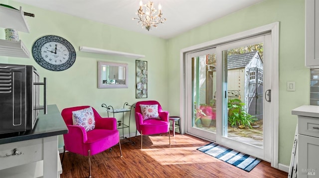 sitting room featuring an inviting chandelier, baseboards, and wood finished floors