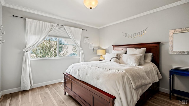 bedroom with light wood-style floors, crown molding, and baseboards