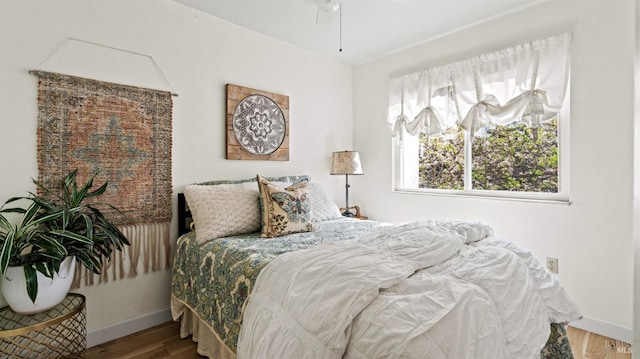 bedroom with baseboards and wood finished floors