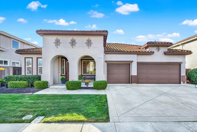 mediterranean / spanish house with a front lawn and a garage