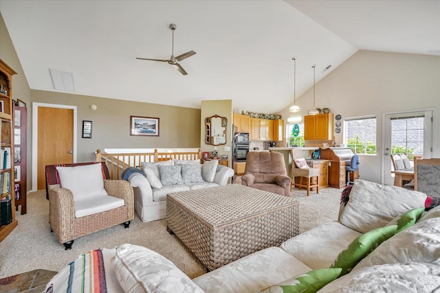 living room featuring ceiling fan, high vaulted ceiling, and light carpet