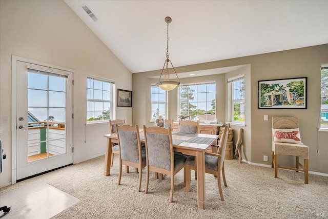 dining space with light carpet, high vaulted ceiling, and a healthy amount of sunlight