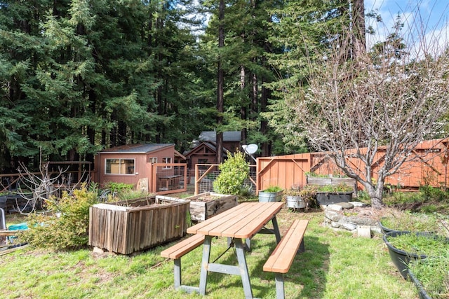 view of yard featuring an outbuilding, a vegetable garden, and fence