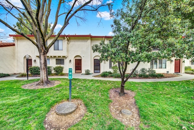 mediterranean / spanish-style home with a front lawn