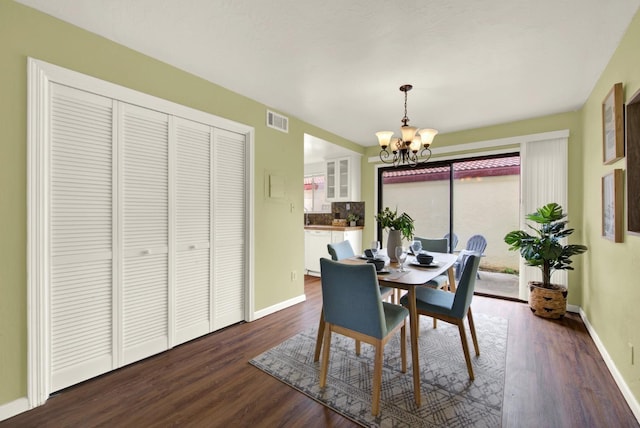 dining area featuring a notable chandelier and dark wood-type flooring