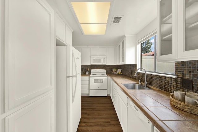 kitchen with sink, white appliances, white cabinetry, backsplash, and tile counters