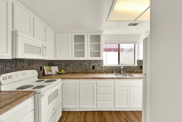 kitchen featuring white appliances, tile counters, sink, and white cabinets