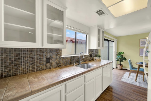 kitchen with tile countertops, tasteful backsplash, sink, white cabinets, and dark hardwood / wood-style flooring