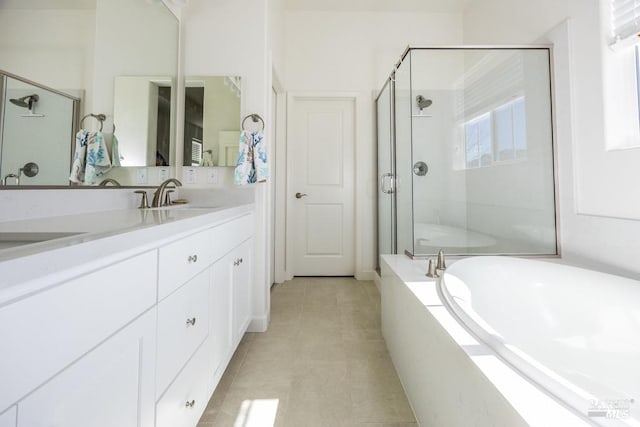 bathroom with a garden tub, a sink, a shower stall, tile patterned floors, and double vanity