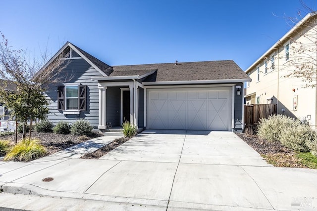 view of front of home with a garage, fence, and concrete driveway