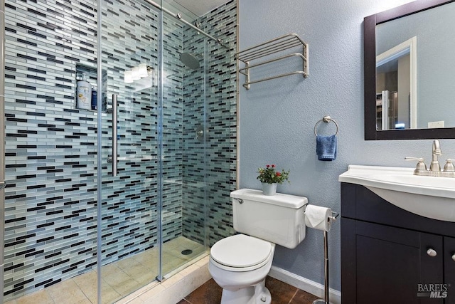 bathroom featuring vanity, toilet, tile patterned flooring, and a shower with door