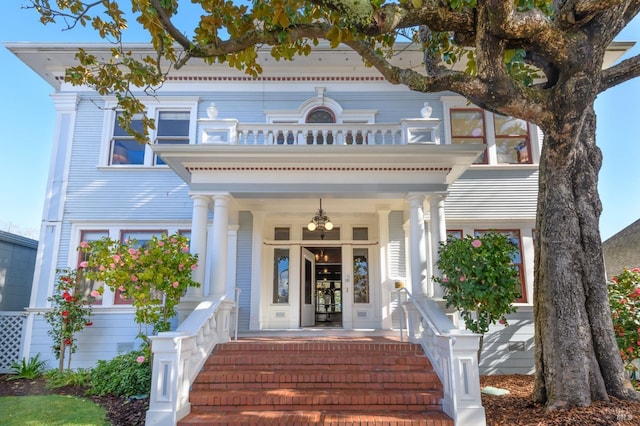 view of exterior entry featuring a balcony