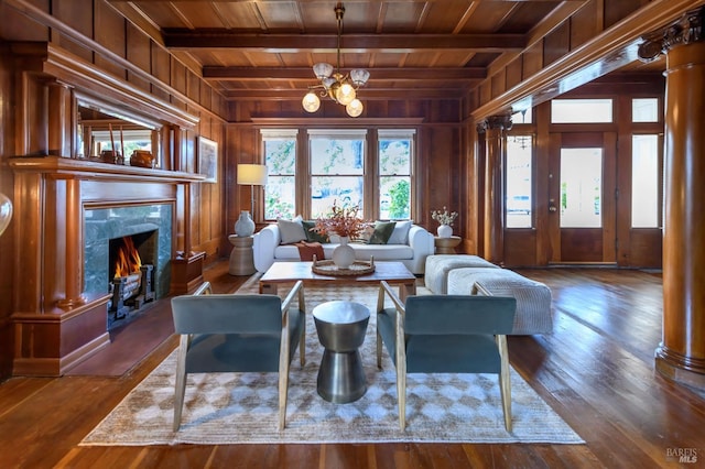living area with wood ceiling, wood walls, wood finished floors, a fireplace, and ornate columns